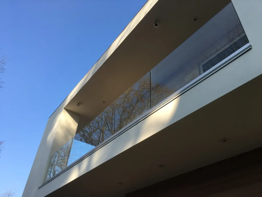 Modern home balcony finished with a clear exterior glass railing