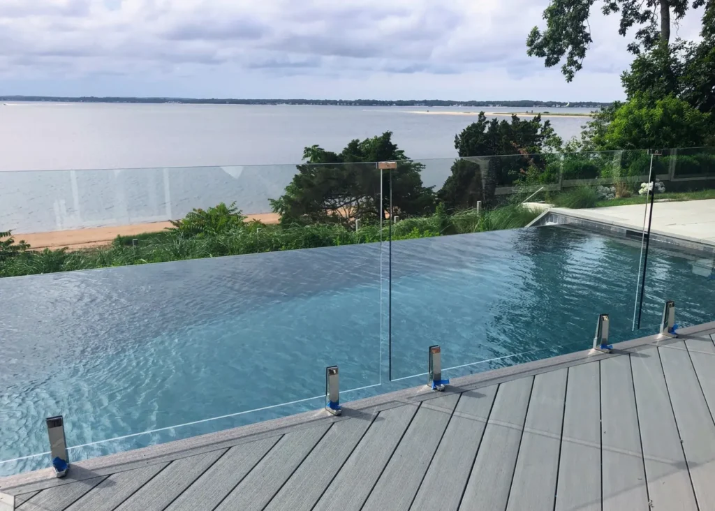 Frameless glass fence surrounding a waterfront infinity pool